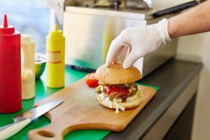 Gloved Hand Preparing Hamburger